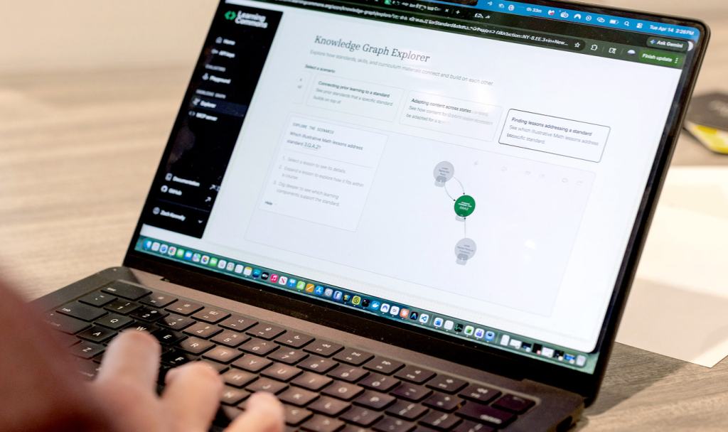 A person's hands typing on a laptop displaying the Learning Commons Knowledge Graph Explorer